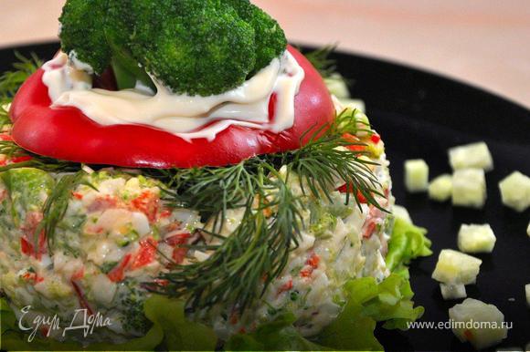 Теперь можно собирать салат. На салатную тарелку положить лист зеленого салата, поставьте на него формочку и наполните заправленным салатом. Снимите форму и декорируйте: немного укропа, затем верхушку от сладкого перца (без плодоножки), в середину добавьте немного майонеза и воткните соцветие брокколи.