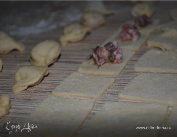 Тесто разделить на 2 части, каждую раскатать тонко и порезать на квадраты со стороной 2-3 см. Должно получится около 100 квадратиков.
В центр квадратика класть немного фарша, сложить треугольником, защипать и соединить углы, как в пельменях.