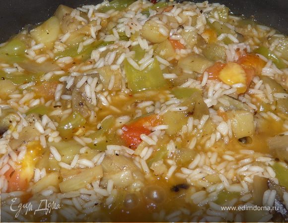 На сковороде подрумянить баклажан (кубиками), перец и чеснок. Добавить водички, потушить пару минут, всыпать рис и через несколько минут мякоть помидоров и оливки. Приправить травками (орегано, мята, базилик...) тушить почти до готовности. 