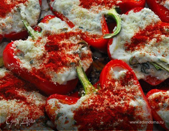 Вынуть перцы, слить вниз противня сок, масло и чеснок. Плотно фаршировать сырной начинкой. Сверху посыпать крошкой пармезана и посыпать паприкой. Вернуть противень в духовку на 15 минут.