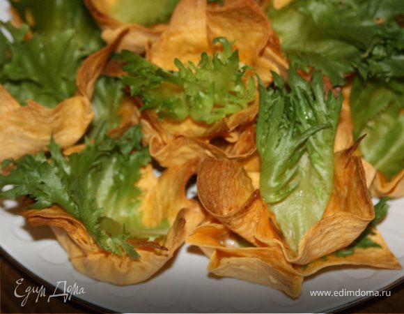 Возьмем лепешку.Нарежем квадратами 15х15 - 12 штук. Смажем их с обеих сторон растительным маслом.(можно майонезом). Выложим крест-накрест по 2 квадрата в форму для кексов, прижмем ко дну. Духовку разогреть до 180*С и подрумянивать корзиночки 10-15 минут. 