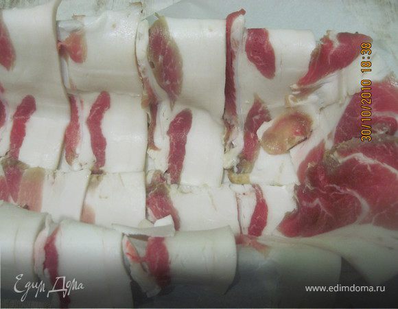 На дно формы постелить бумагу для выпечки. Бока формы выложить в шахматном порядке полосками бекона так, чтобы они свисали с краев. 
