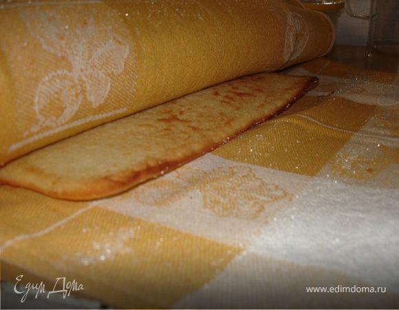 Бумагу слегка увлажнить водой, аккуратно удалить её (я не увлажняла) и с помощью полотенца осторожно свернуть корж рулетом