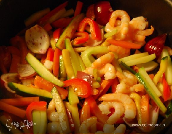 Нарезать все овощи, включая чеснок соломкой. Половинку луковицы не резать, а отделить "лепестки" и обрезать хвостик и корешок.
Поставить воду кипятиться.
На сковородку налить немного подсолнечного масла,как только оно погреется можно кинуть туда чайную ложку кунжутных семечек.Затем добавить туда чеснок, затем добавить морковь,огурец,цуккини,перец и лук и креветки и смесь соленого и сладкого(2 ст ложки соленого и 1 чайная сладкого соевого соуса или 2 ст л ложки соленого+ пол чайной ложки сахара).Обжаривать помешивая на большом огне. 