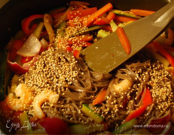 В закипевшую воду бросить 100 гр гречневой лапши и подержать там 5 минут. Через 5 минут откинуть лапшу на дуршлаг, и отряхнув от воды выложить в сковороду к овощам и хорошо перемешать.Добавитьнемного кунжутного масла, посыпать кунжутными семечками. Попробовать на вкус, если вкус недостаточно соленый добавить соевого соуса.
Выложить в миску.Одну общую или сразу в порционные.
Украсить водорослями. Как вариант можно подать с мелко порезанными нори.