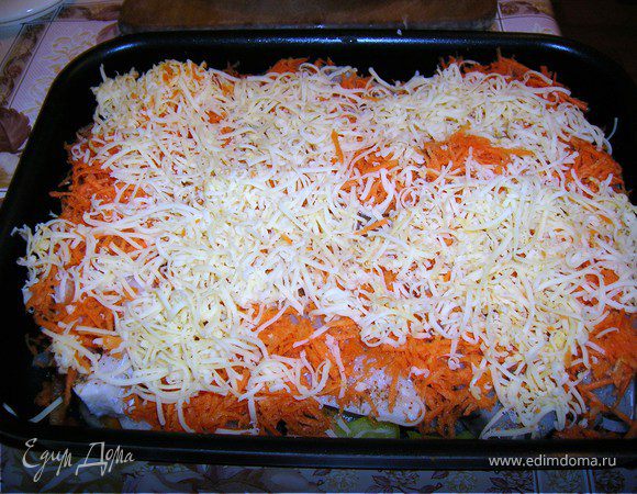 На рыбу выложить тертую морковь и сыр.
Накрыть мокрым пергаментом  и выпекать при 200 градусах 20 мин с бумагой и 10 мин без бумаги до румяности.

