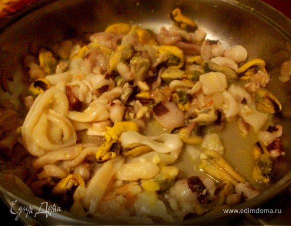 Добавляем морепродукты, желательно уже полностью размороженные. Морепродукты будут выделять много жидкости, которую желательно сливать в отдельную чашку, но не выливать совсем. Этот бульон может потом пригодиться. Готовить несколько минут, пока морепродукты немного не поджарятся.