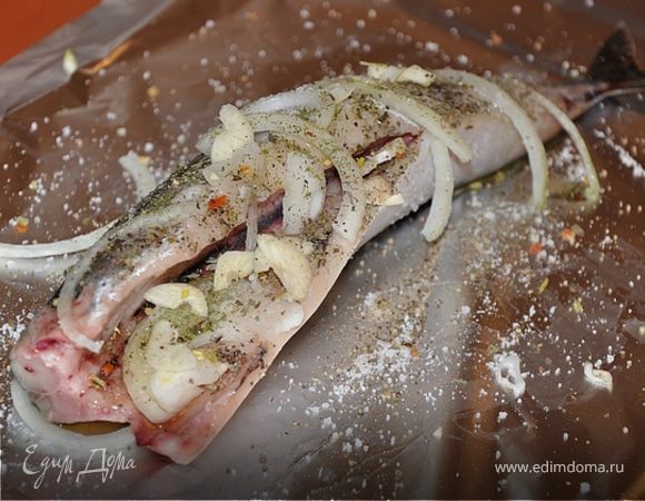 Кладём рыбку на фольгу, солим, перчим, добавляем лук, чеснок. Приправу я использую Весеннюю фирмы "Волшебное дерево". Она без консервантов, с морской солью.Немного сбрызгиваем оливковым маслом. 