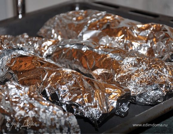 Заворачиваем рыбу в фольгу и складываем на противень.
