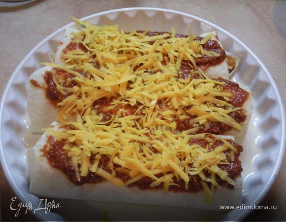 Форму для запекания смазать растительным маслом и уложить рулетики. Каждый полить томатным соусом и присыпать сыром.