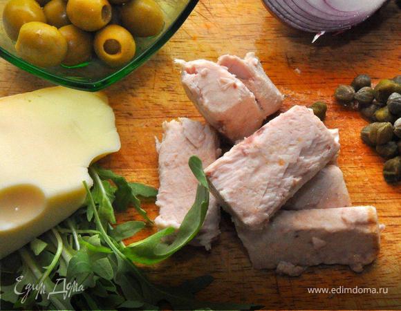 Тесто раскатать толщиной 5мм и диаметром 30см. Выровнять края, используя плоскую тарелку такого диаметра. Положить тесто на кулинарную бумагу, перенести на решетку и отправит в духовку, разогретую до 180 гр. на 2 минуты. Это для того, чтобы не пересушить нежную начинку из тунца и вместе с тем довести тесто до готовности.