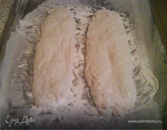 Наша опара подошла. Займемся тестом. В чашу того же комбайна просеять муку, добавить соль, сахар и разведенные дрожжи. Маленький секрет. Дрожжи разведем в газированной воде, для большей пузырчатости и "дырявости" нашего хлеба. В конце замеса добавим оливковое масло. Готовое тесто переложим на обсыпанную мукой поверхность, накроем мокрым полотенцем и оставим отдыхать на 1,5 часа.Затем займемся формированием нашей чиабатты. Аккуратно, без лишних нажимов разделим тесто на 2 колобка. На сухой присыпанный мукой протвинь нежно переложим 1 колобок, слегка вытигивая его в продолговатую форму.Со вторым проделаем тоже самое. Накроем мокрым полотенцем и оставим еще на 1,5-2 часа.