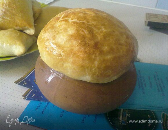 А теперь раскатать заранее подготовленное тесто в пласт толщиной не меньше 0,5 мм, вырезать кружки чуть больше диаметра горлышка горшочка. 
Затем смазать края взбитым желтком и плотно накрыть кружком теста, прижать и подержать некоторое время, чтобы "крышечка" приклеилась.
Смазать "крышечки" взбитым яйцом и отправить в духовку на средний огонь до румяной корочки "крышечки". А теперь срезаем крышечку и вприкуску наслаждаемся вкуснейшим рагу из дымящегося горшочка!!!  