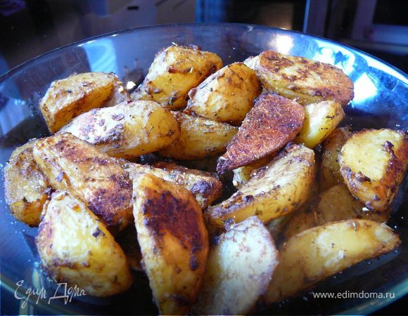 Слить воду, а картофель переложить в глубокую миску. Сверху вылить заправку и миску хорошо потрясти, для равномерного распределения. Тем временем сухой протвинь поместить в духовку и предварительно разогреть. Как сковородка/протвинь раскалится, вывалить наши дольки и запечь при температуре 200 С в течении 20 минут. Подавать немедленно,с горчицей, кетчупом или соусом из сметаны, чеснока и зелени. Приятного аппетита!