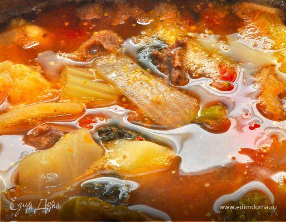 В готовый бульон поочередно закладываем овощи. Сначала картофель, морковь и сельдерей, через 5-7 минут всю капусту и фасоль, еще через 10 минут тыкву и лук. Пока овощи варятся, разобрать мясо и нарезать его на средние кусочки и добавить в похлебку одновременно с рублеными томатами.