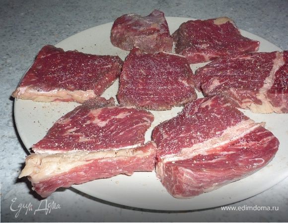 Говядину нарезать порционными кусками, отбить, посолить, поперчить.