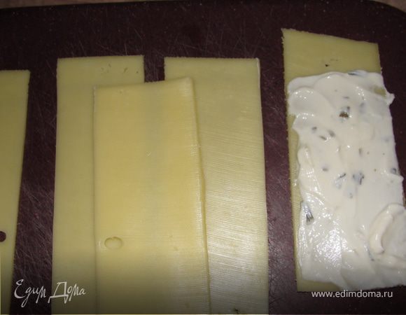 Смазываем сырным кремом с одной стороны не до конца и сворачиваем в улитки.