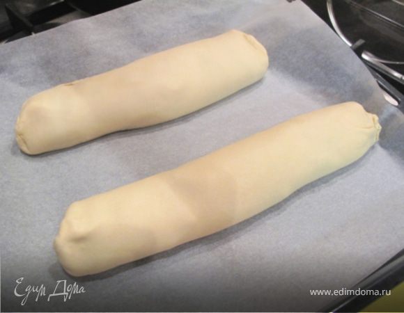 На раскатанное тесто, выложить начинку и свернуть. Края плотно закрыть и смазать рулет желтком.