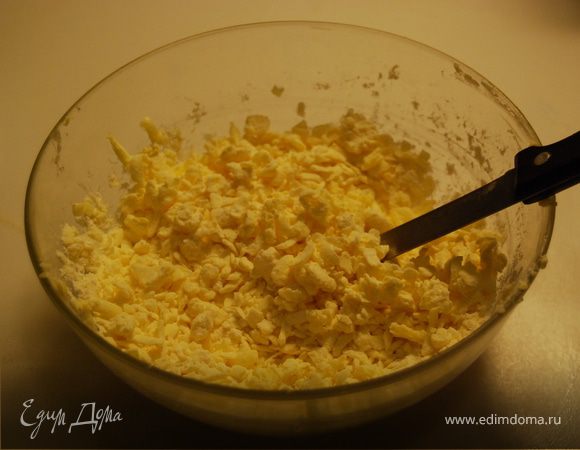 Сливочное масло натереть на крупной терке и соединить с мукой, продолжая до тех пор, пока масса не станет довольно однородной, а кусочки мелкими, как крошки.
Добавляем сахар и творог, быстро замешиваем тесто, заворачиваем в пленку и ставим его в холодильник на полчаса-час.
