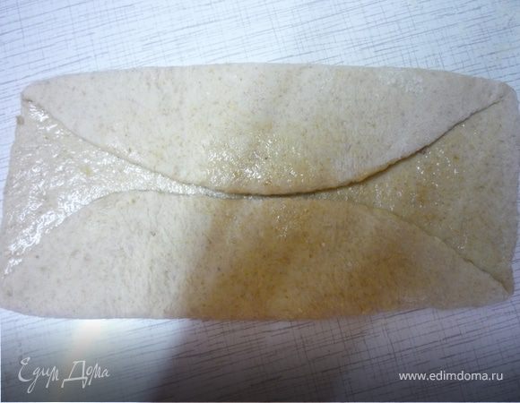 Берем шар теста, раскатываем круг, смазываем растительным маслом и сворачиваем два края к центру. 