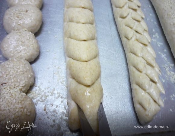 Для приготовления багета "Колосок" раскатываем багет, как в базисном рецепте, а на тех этапах, когда тесто смазывают растительным маслом, посыпаем по  столовой ложке очищенных и обжаренных семян подсолнечника. Багет смазываем водой или растительным маслом и выкладываем на противень. Берем ножницы и делаем глубокие надрезы на 2/3 на расстоянии 3 см. 