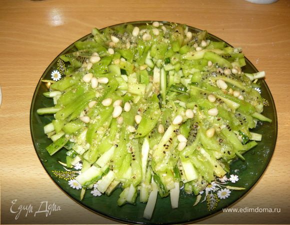 Почистить киви и тоже порезать соломкой. Выложить последний слой, полить заправкой. Украсить кедровыми орешками.
