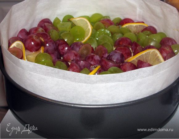 Виноград вымыть, разрезать на половинки и вытащить косточки. Выложить на бисквит виноград и тонкие ломтики лимона. Поставить в холодильник охлаждаться.