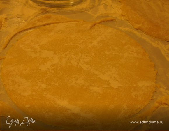 Разделить тесто на 8 кусочков. Раскатать каждый очень тонко. С помощью большой тарелки вырезать круги.Обрезки оставить для обсыпки.