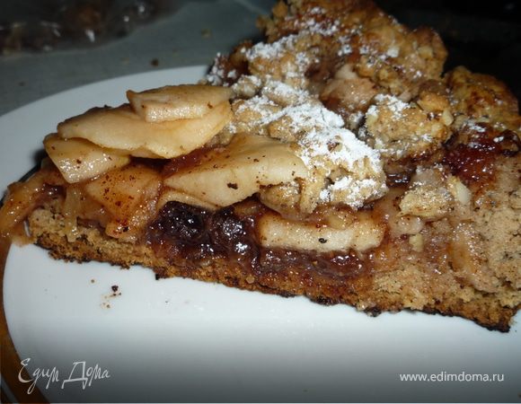 Вынуть тесто из холодильника и отщипнуть от него небольшой кусочек (он пойдет для украшения). остальное тесто распределить по форме для запекания, делая бортики. Выкладываем яблочную смесь и равномерно распределяем. Отложенное тесто смешиваем с отложенными орехами и крошим поверх начинки, оставляя середину. 
Выпекать около 25 мин или пока пирог не зарумянется. Вынуть из духовки и остудить его мин 10. 
Приятного аппетита!!