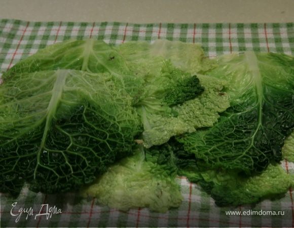 Вырезать жесткую серцевину у основания листьев капусты,опустить листья на 3 минуты в ,слегка подсоленную,воду.Откинуть на дуршлаг и обдать холодной водой.Выложить их на кухонное полотенце,прижать руками,чтобы листья стали совсем плоскими и дать обсохнуть.