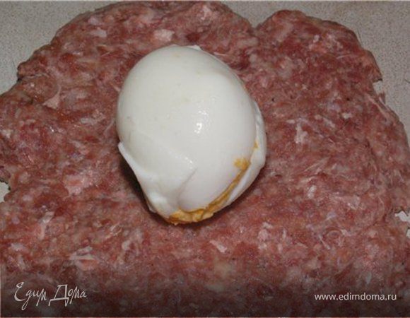 Фарш разделить на 7 равных частей, сформировать лепешки. В центр лепешек положить начиненное яйцо и сформировать овал.
Выложить зразы на противень, застеленный пергаментом и запекать в духовке 30-40 минут при температуре 200 градусов.

