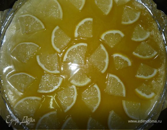 Форму для выпечки 28 см смазать рафинированным растительным маслом, выстелить фольгой (бумагой для выпечки), вылить половину карамели и выложить резаный лимон. 