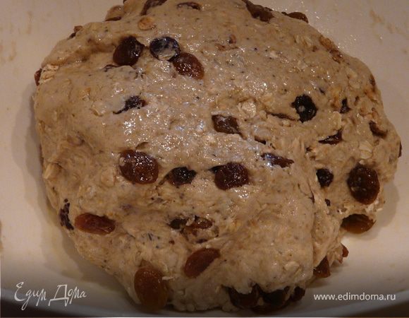 Замесить липкое тесто и в него вмешать изюм и мюсли. Ягоды в себя вберут влагу, поэтому тесто не должно быть совсем сухое.
Смазать миску маслом и положить в нее тесто на 1-1,5 часа до увеличения в обьеме.