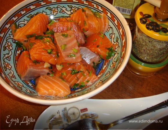 Пока овощи жарятся, нарежьте рыбу кубиками со стороной 3-4 см. Затем положите кусочки рыбы в миску с растительным маслом и осторожно перемешайте, чтобы все кусочки покрылись маслом.