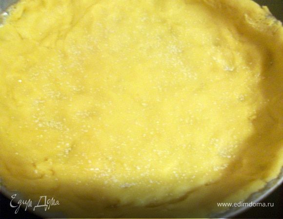 Смазать форму маргарином, выложить тесто. Сверху еще посыпать ванильным сахаром. На фотографии, если присмотерться, это видно.
