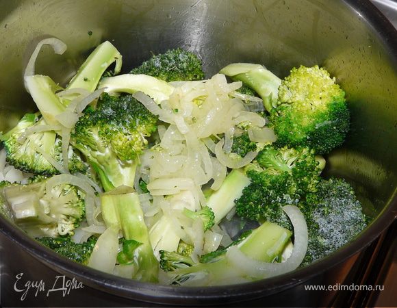 В высокую кастрюлю налить оливковое масло, положить лук и несколько минут протушить, добавить порезаную на маленькие соцветия брокколи и подержать несколько минут.