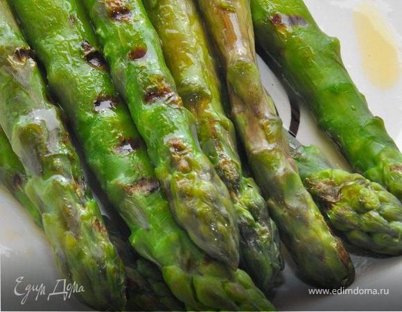 В это время обжарить спаржу без масла на гриль-сковороде равномерно со всех сторон, выложить в миску и немного смазать сливочным маслом.