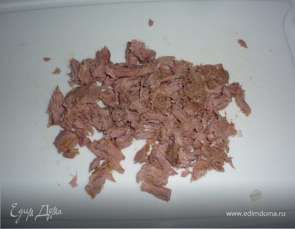 Сливаем сок из банки с тунцом, разбираем филе на более мелкие части.