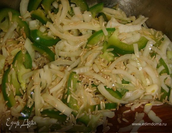 Добавить в кастрюлю еще 1 ложку растительного масла. Положить в кастрюлю лук, сладкий перец и чеснок и обжарить до полупрозрачности лука. Добавить в кастрюлю рис, и жарить его минуты 2, чтобы он впитал в себя все ароматы.