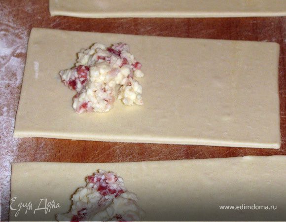 Тесто немного раскатать. Нарезать прямоугольниками. Выложить на одну половинку начинку.