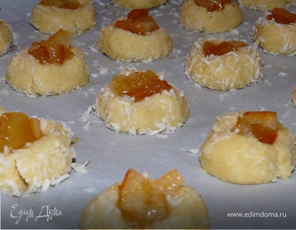 Замесить (удобнее пользоваться миксером) тесто, слепить его и в пакете отправить в холодильник на 30 мин.
Разогреть духовку до 175С. На бумагу для выпечки выложить маленькие шарики из теста (ок. 3см), сперва окунув их в яичной смеси, затем обваляв в кокосе. Каждый шарик придавить пальцем и в центр выложить чуть джема (здесь апельсиновый).
Печь ок.20 минут (кокос станет коричневатым).