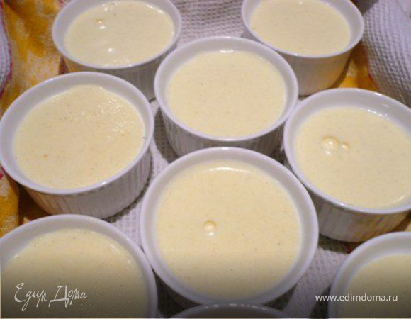 Глубокий поднос выложить полотенцем (чтобы формочки не елозили) и поставить на него формочки. Залить горячей водой до половины формочек. Накрыть поднос фольгой. Запекать  в разогретой до 180 С духовке 40-45 минут. Масса должна схватиться, но в середине быть пружинистой.
