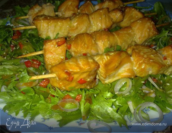 В маринад, где была рыба, добавит еще немного соевого соуса,  тонко нарезать лук-шалот, салатные листья выложить на блюдо, посыпать луком-шалотом и полить маринадом. Сверху выложить шашлычки.