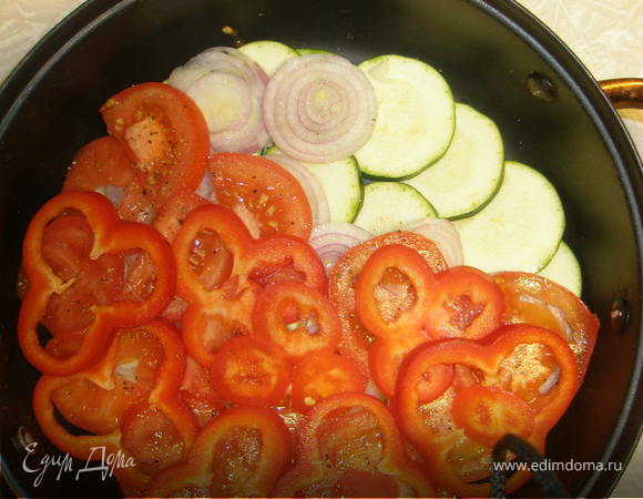 В глубокую сковородку выложить слоями: кабачки, затем лук, помидоры и перец. 