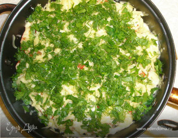 Влить воду, разложить дольки чеснока. Накрыть крышкой и тушить на маленьком огне 40 мин. Затем посыпать сыром и зеленью и тушить под крышкой еще 2 минуты.