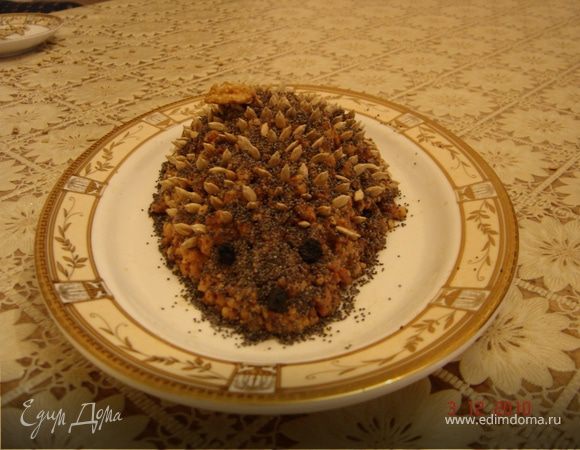 Из получившейся массы слепить ёжика. Посыпать маком и воткнуть иголки-семечки, глаза и носик из изюма.