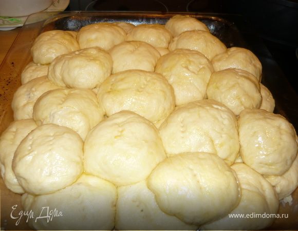 Слепить небольшие пирожки. Каждый пирожок обмазать растопленным сливочным маслом. Выкладывать рядом друг с другом на противень не слишком плотно, т.к. они еще будут подходить, но и не слишком свободно, т.к. они должны будут сформироваться в пирог. Положить второй слой. Выпекать в духовке до готовности. Я обычно пеку около 40 минут на 180 градусах с режимом конвекция. Или просто на 200. Минут за 10 до готовности можно смазать желтком для красоты.