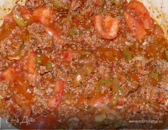 Теперь положить травы и специи, томатную пасту, помидоры. Влить пиво. Тушить чуть больше часа, пока мясо не приготовится, ближе к концу добавить фасоль. 
При подаче можно посыпать сыром.