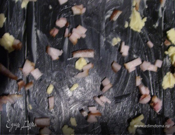 Протвень натираем маслом. Шпик режем мелкими кубиками, распределяем по листу.