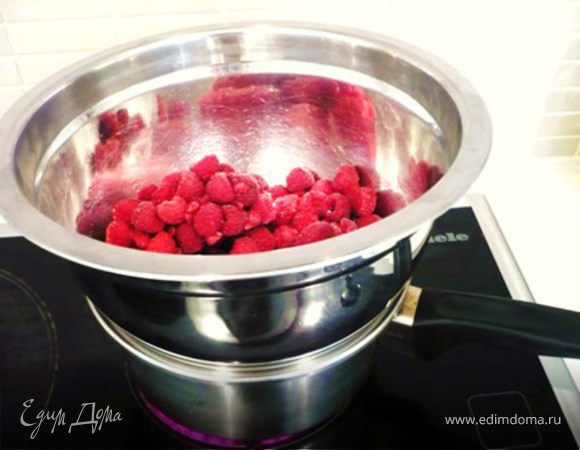 МАЛИНОВОЕ ЖЕЛЕ:  Засыпать в миску мороженную малину. Мороженная дает больше сока, чем свежая.  Несколько ягод сохранить для украшения, если нет свежей. Поставить малину на водяную баню и размораживать, пока малина полностью не оттает и даст много сока. 
